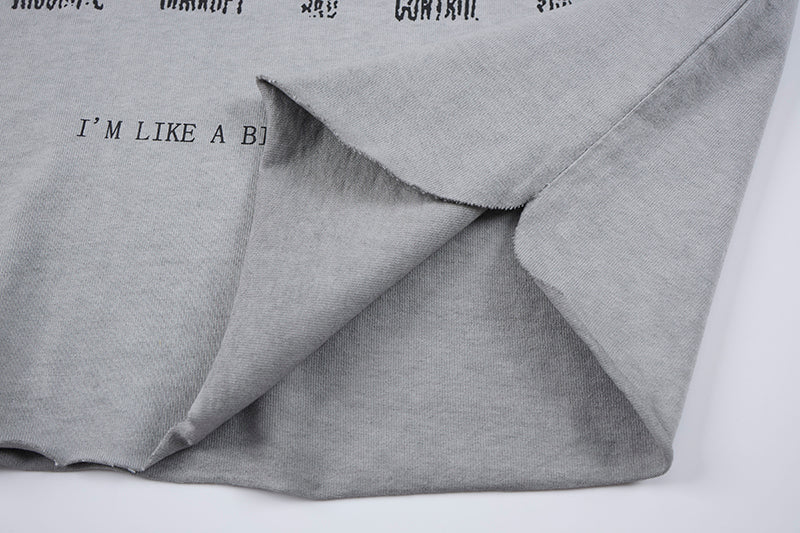 Distressed gray sleeveless gothic T-shirt with layered raw hems and printed text detail