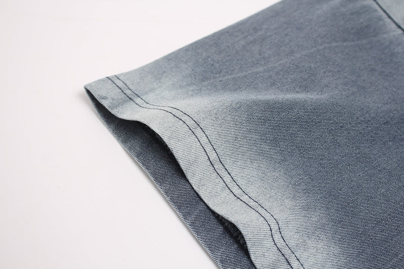 Close-up of a washed blue-gray vintage T-shirt sleeve with faded dye and double-stitched hem detail