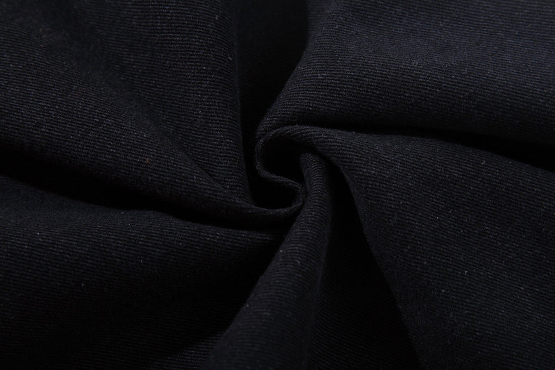 Close-up of black denim fabric texture folded in soft drapes