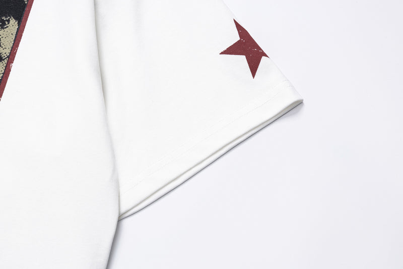 White graphic tee with a maroon star print and vintage panel detail on the sleeve, shown in a close-up flat lay
