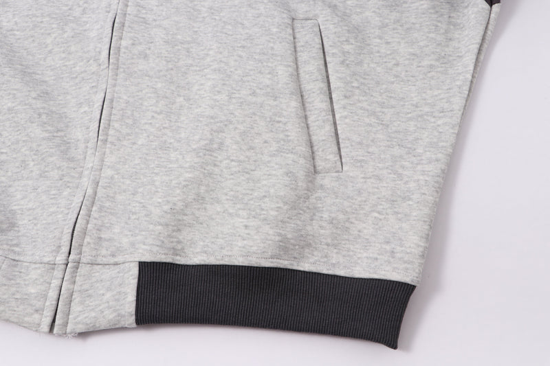Lower front view of light gray hoodie with pocket, side seam, and ribbed hem