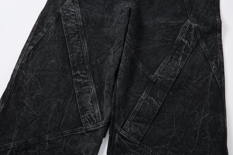 Close-up of front leg panels on black wide-leg denim jeans