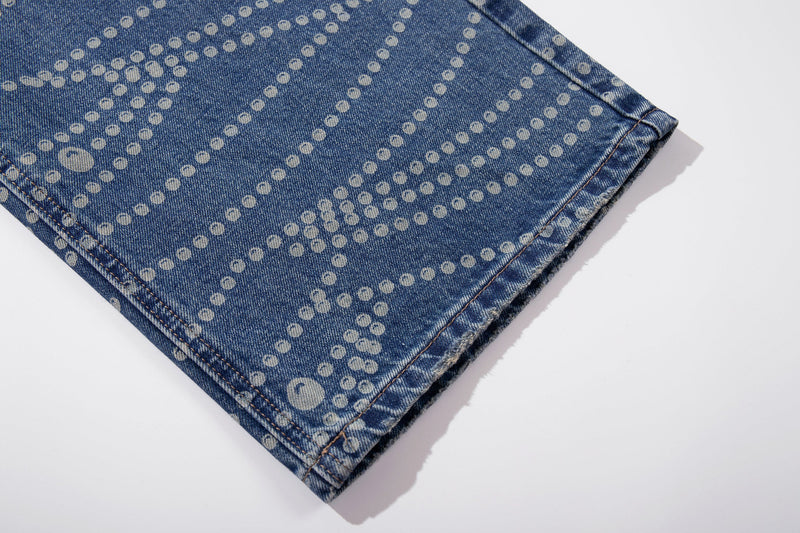 Close-up of hem on wide-leg blue denim pants with dot pattern