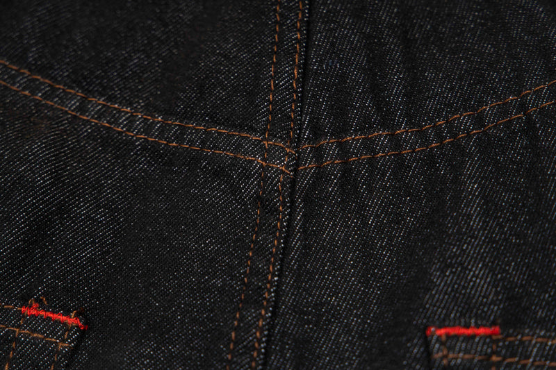 Close-up of dark wash denim stitching and pocket seam details