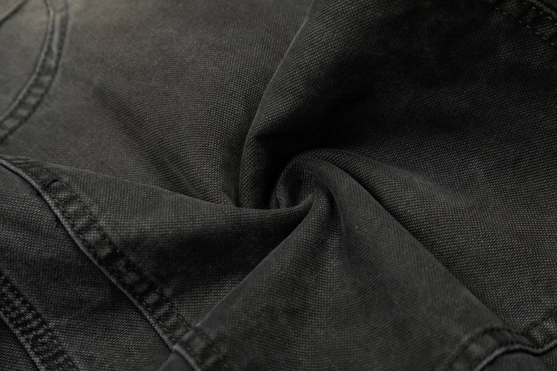 Close-up of black denim fabric texture and seam stitching on cargo pants