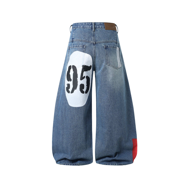 Blue wide-leg jeans back view with graphic print on the left leg
