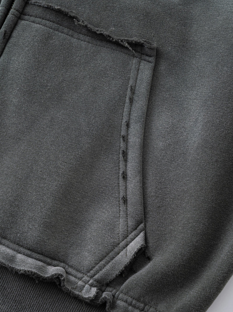 Close-up of gray hoodie front pocket with frayed edge and seam detail