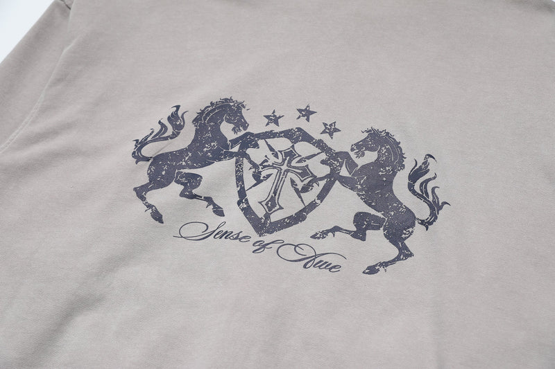 Close-up of back graphic on light gray hoodie with horses and crest design