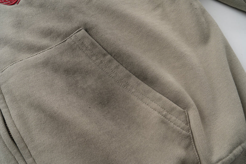 Front kangaroo pocket detail on taupe zip-up hoodie