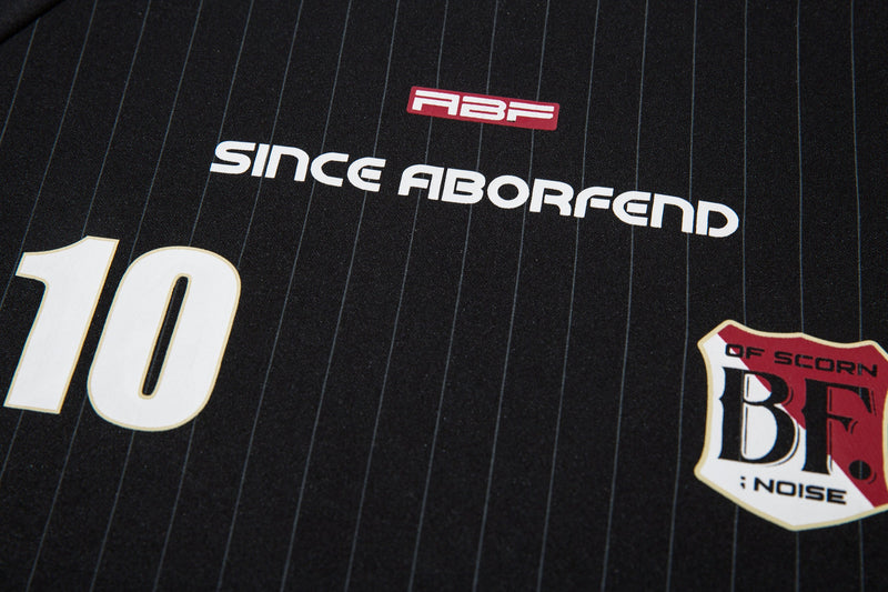 Close-up of black jersey front chest with number 10, logo, and pinstripes