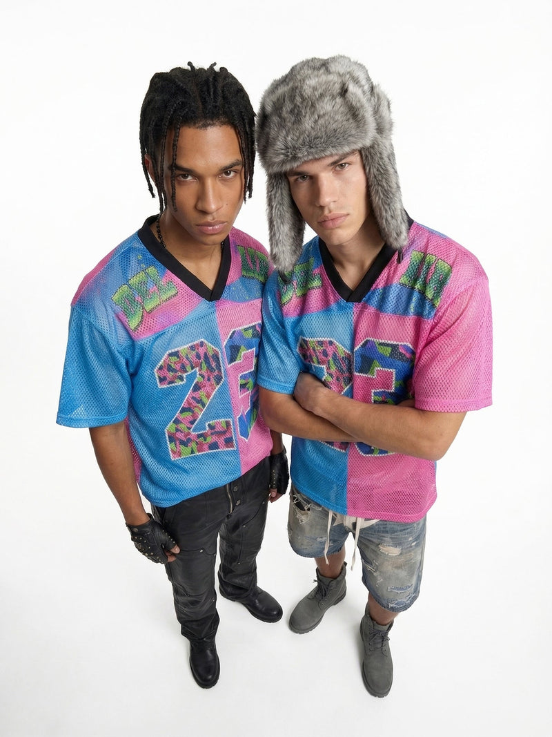 Two men wearing split-color mesh jerseys with bold number 23 graphic in blue and pink, styled with streetwear accessories