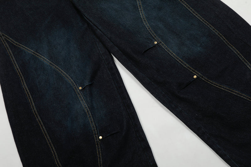 Flat lay of both legs on dark wash wide-leg denim pants with curved seam panels and snap details