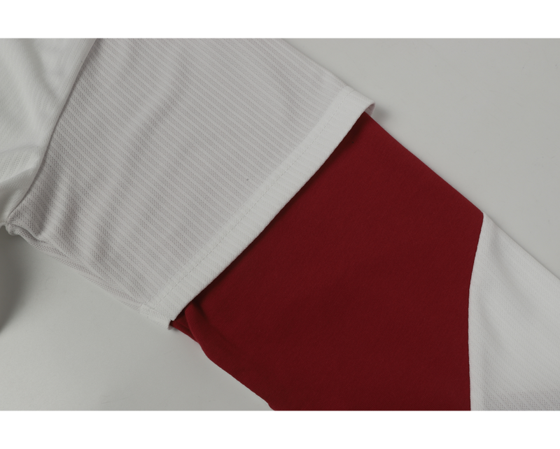 Close-up of red and white sleeve cuff on white mesh hockey jersey