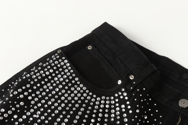 Front waistband and pocket opening on black jeans with rhinestones