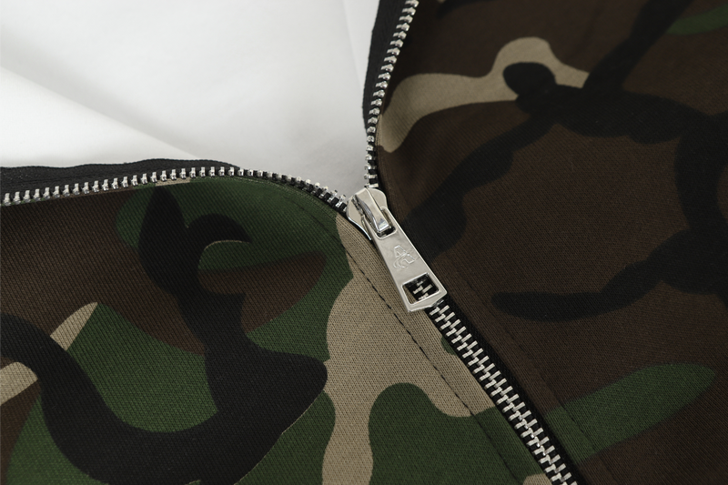 Close-up of front zipper on camo hoodie with silver zip teeth