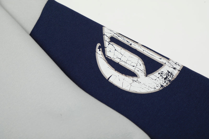 Close-up of navy sleeve with cracked white graphic detail on the upper arm