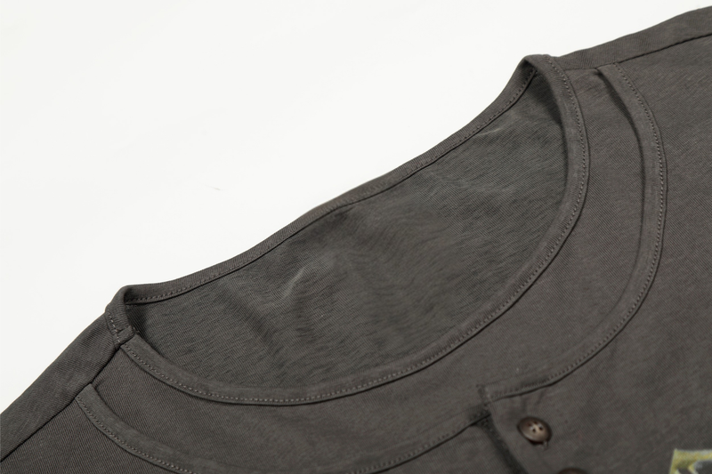 Close-up of charcoal tee neckline with stitched seam and layered collar detail