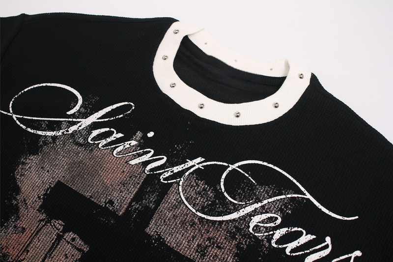 Black gothic graphic tee with white studded collar and distressed script print on the chest