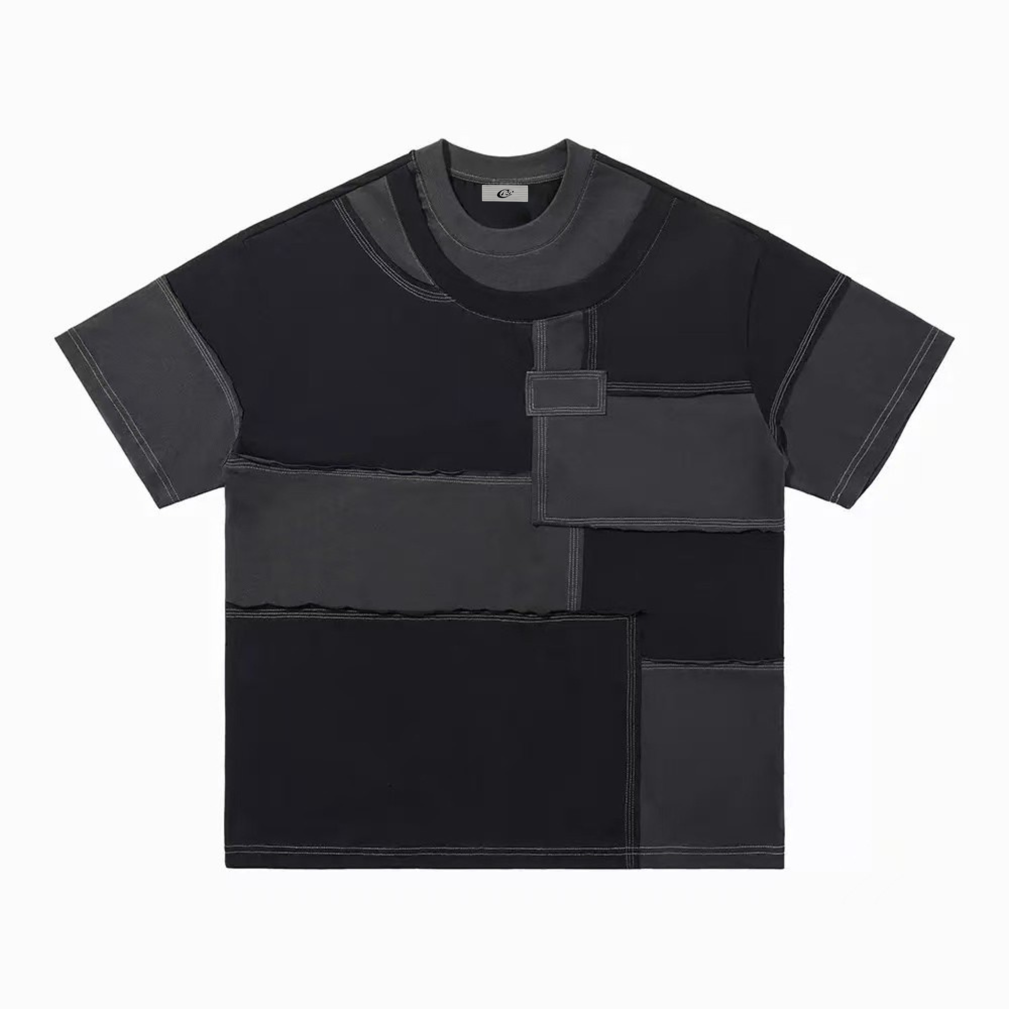 Flat lay of a black and charcoal grey patchwork panel oversized t-shirt with exposed contrast stitching