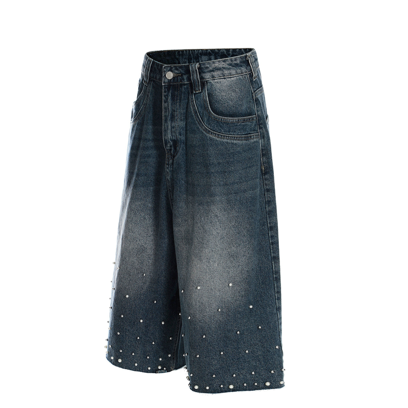 Side front view of blue denim shorts with wide legs, front pocket and stud details