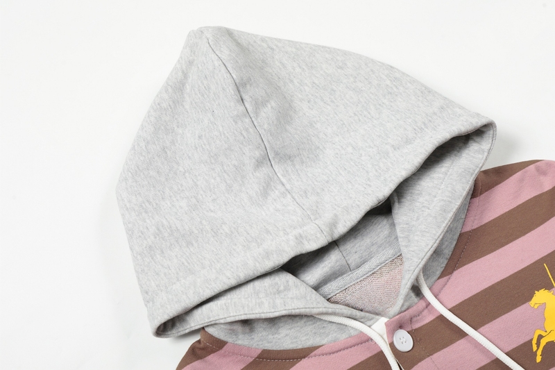 Close-up of grey hood on striped hoodie with white drawstrings and visible lining