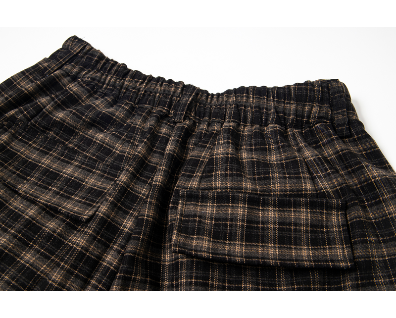 Close-up of back elastic waistband and flap pocket on plaid cargo shorts