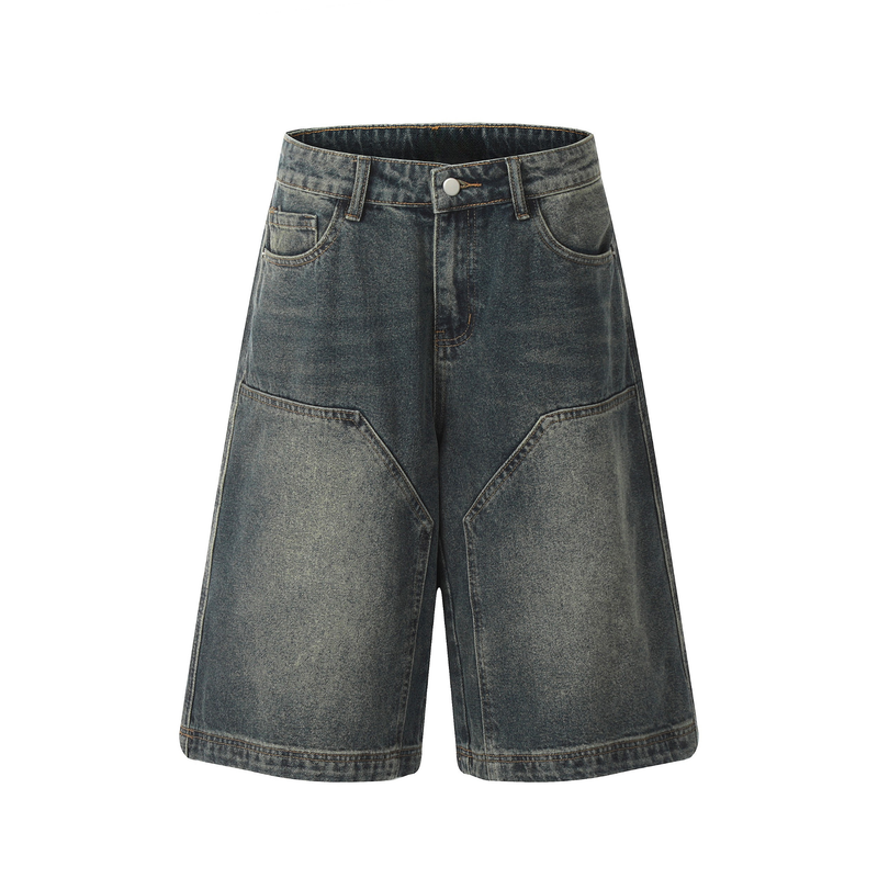 Front view of dark wash wide-leg denim shorts with geometric panel seams and five-pocket styling