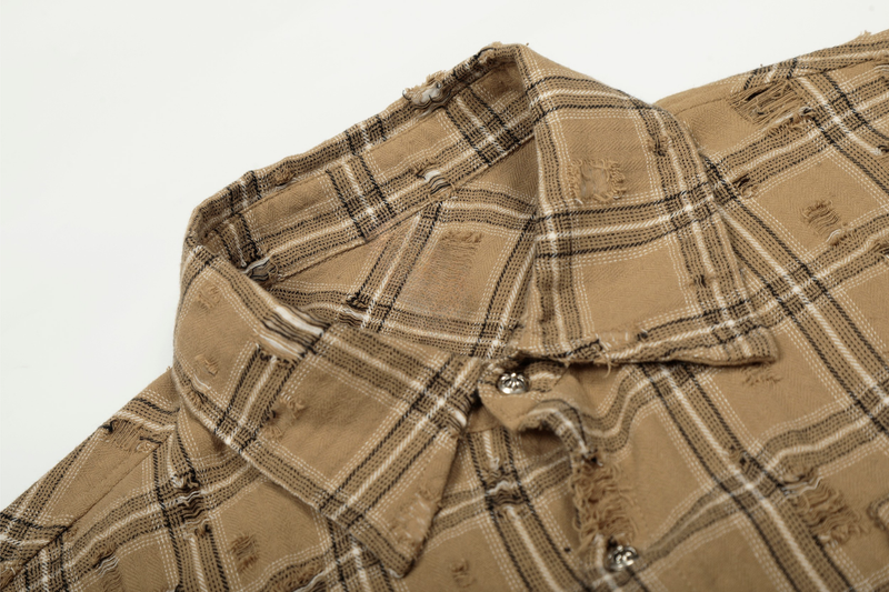 Close-up of tan plaid shirt jacket collar and distressed shoulder detail