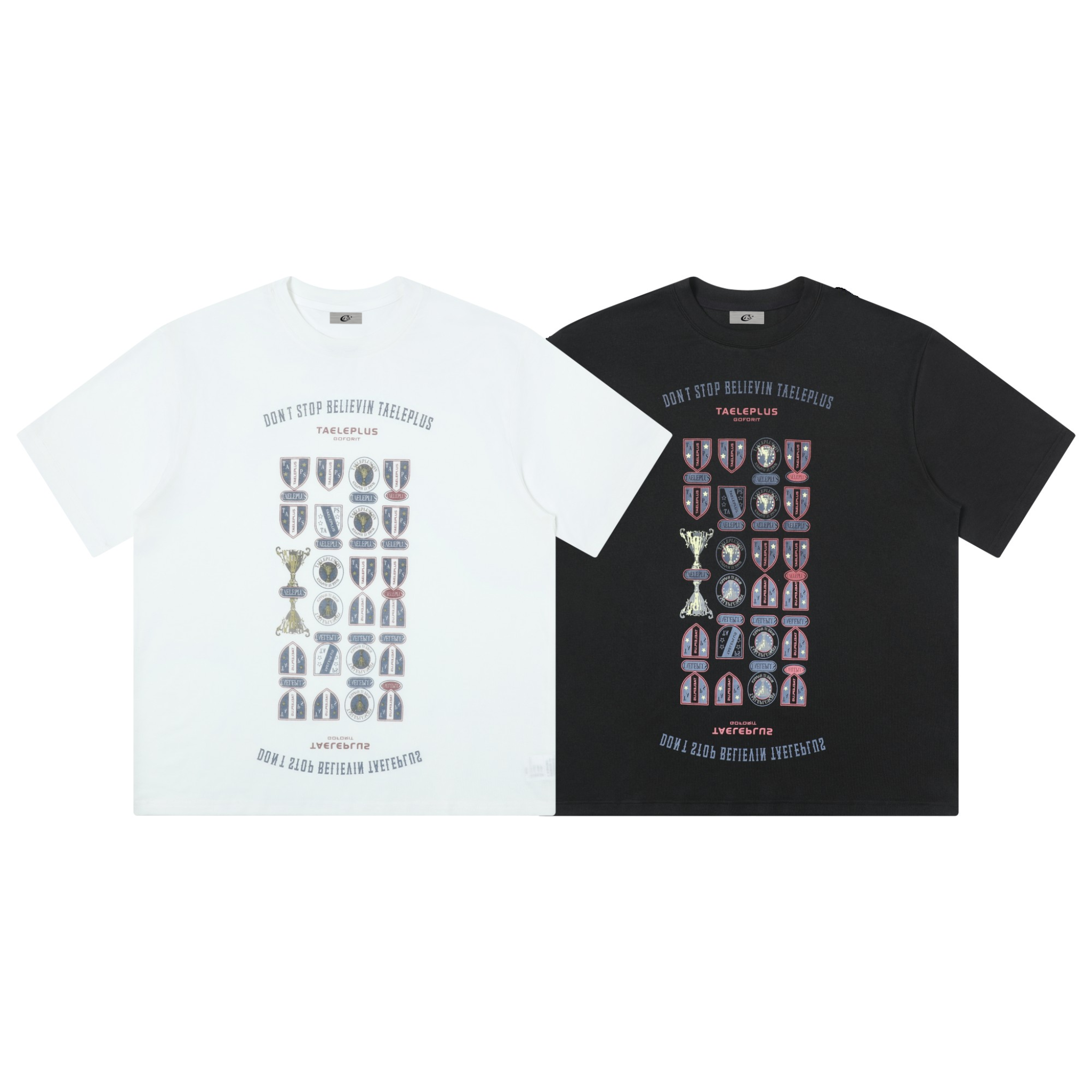 White and black Don't Stop Believin trophy and shield emblem graphic tees laid flat side by side