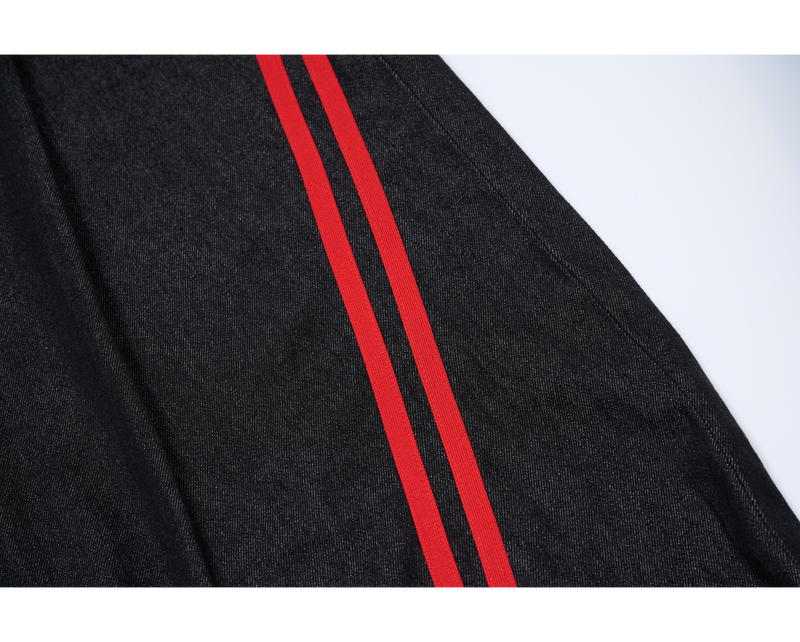 Side leg close-up showing twin red stripes on dark denim pants
