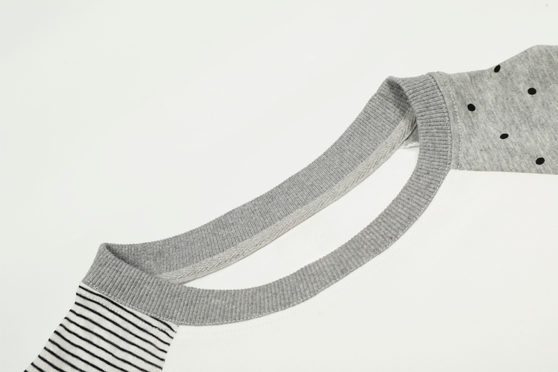 Close-up of gray ribbed neckline, raglan seam, and striped to polka dot sleeve transition