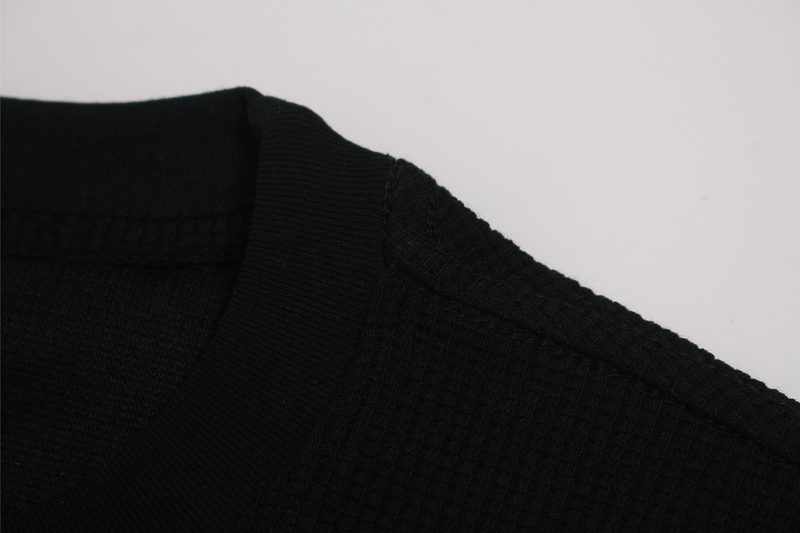 Black streetwear graphic tee with ribbed crew neck and subtle cross typography print detail