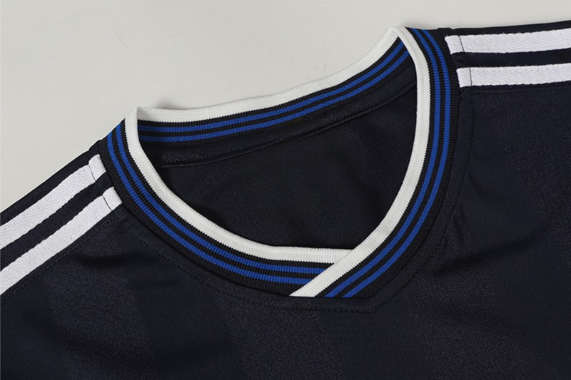 Black soccer jersey with white and blue striped ribbed collar and shoulder stripes, close-up detail view