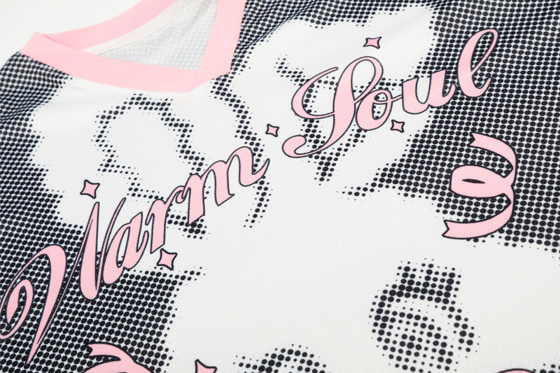 Close-up of a white mesh jersey with pink V-neck trim, star pattern, and bold Love text graphic