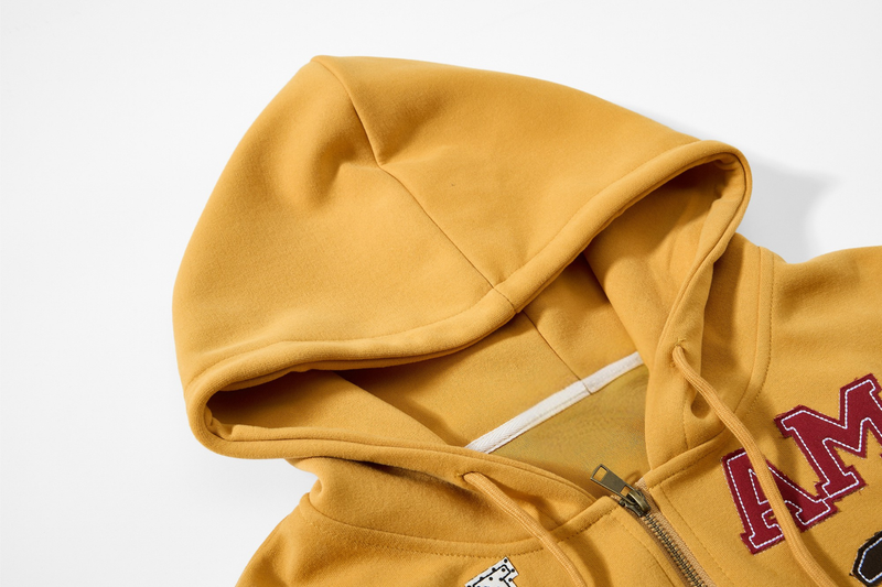 Close-up of mustard yellow hoodie hood and upper chest with zipper and drawstrings