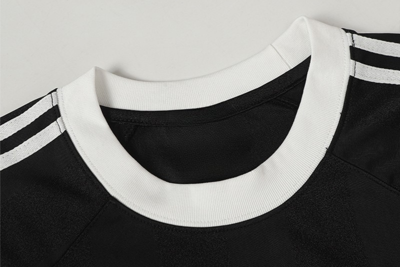 Black football jersey T-shirt with white ribbed collar and shoulder stripes, sporty club style