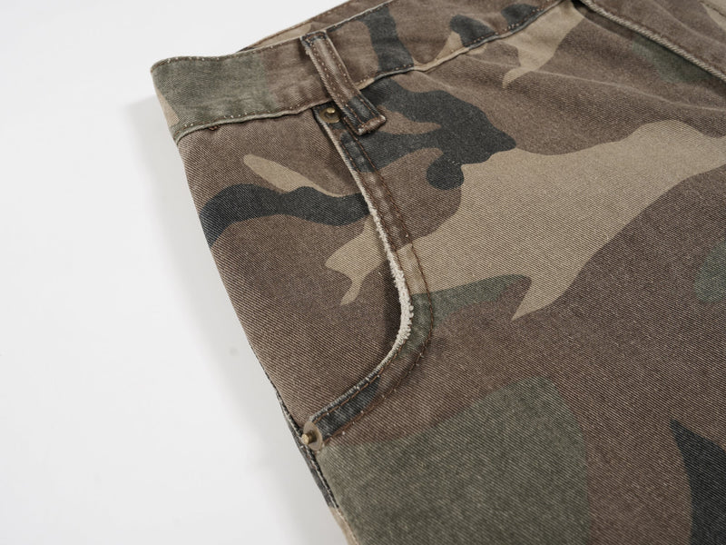 Close-up of camo front pocket edge with stitched seam and rivet detail