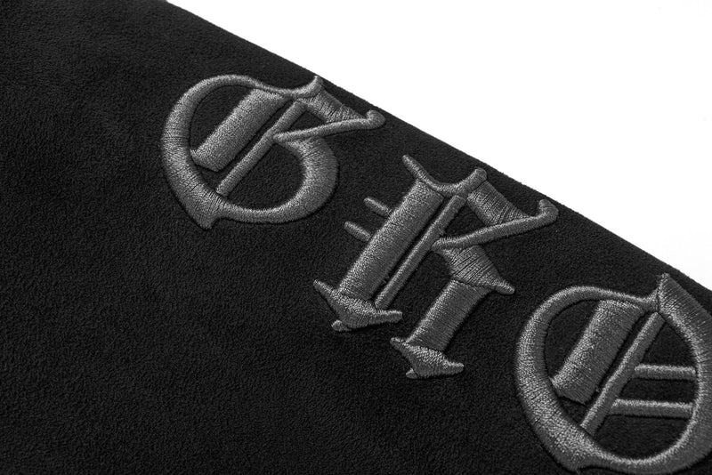 Close-up of embroidered sleeve lettering on black suede hoodie