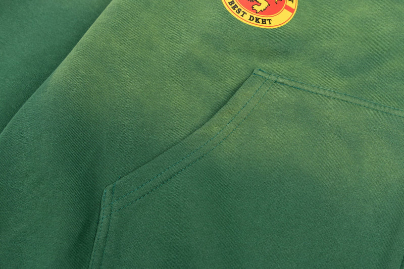 Close-up of green hoodie front pocket seam and faded fabric texture