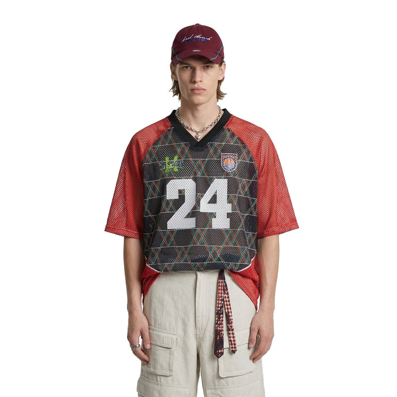 Model wearing a red mesh varsity jersey with black front, large 24 graphic, and color block streetwear styling