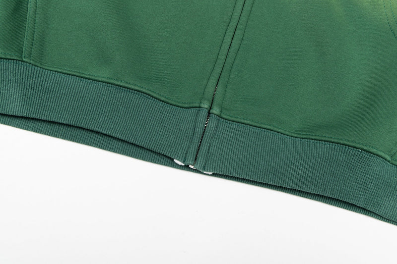 Close-up of green hoodie ribbed hem and zipper bottom
