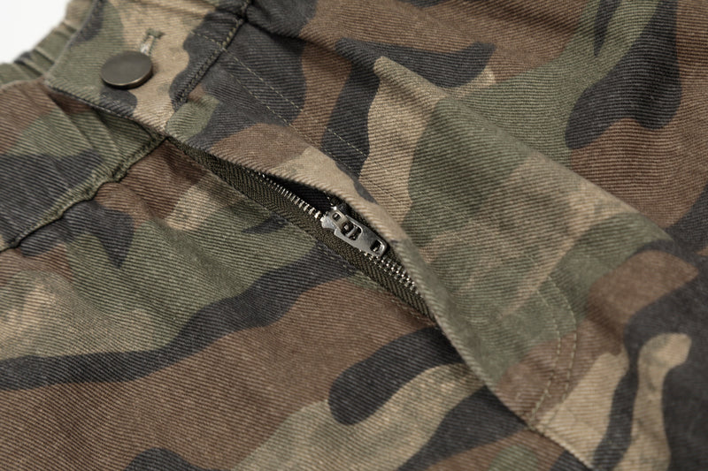 Close-up of zipper pocket detail on green brown camouflage shorts