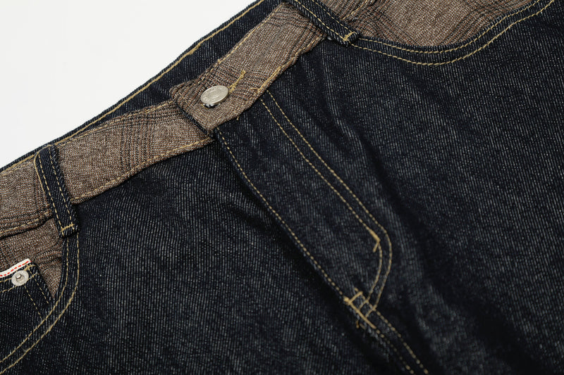 Close-up of front waistband and button on dark wash jeans with contrast trim