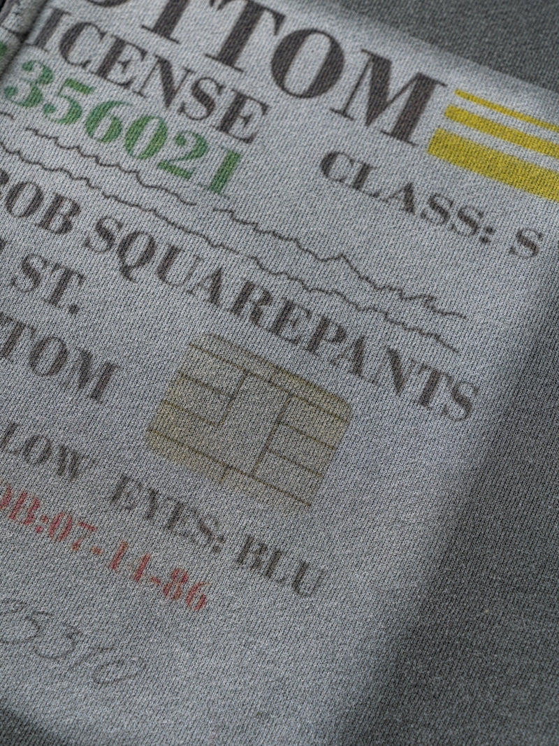 Close-up of gray hoodie print details and faded graphic text