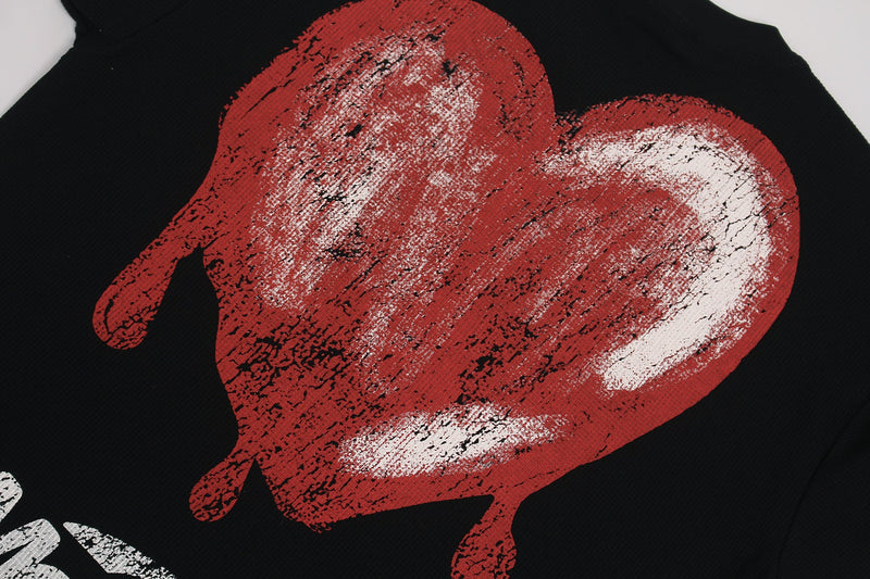 Black graphic tee with a distressed red melting heart print and bold streetwear style
