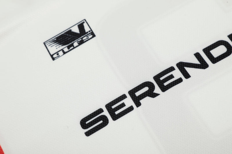 Close-up of Serendipity logo patch on white jersey fabric