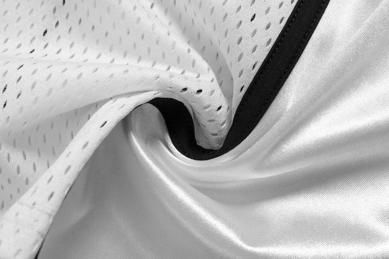 Close-up of white mesh and satin fabric seam with black trim
