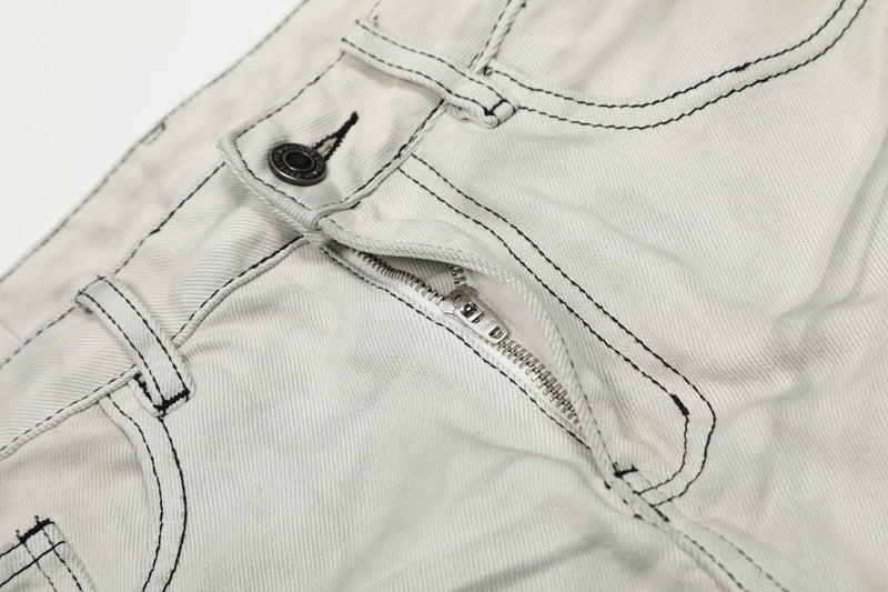 Close-up of front button and zipper fly on light gray jeans with contrast stitching