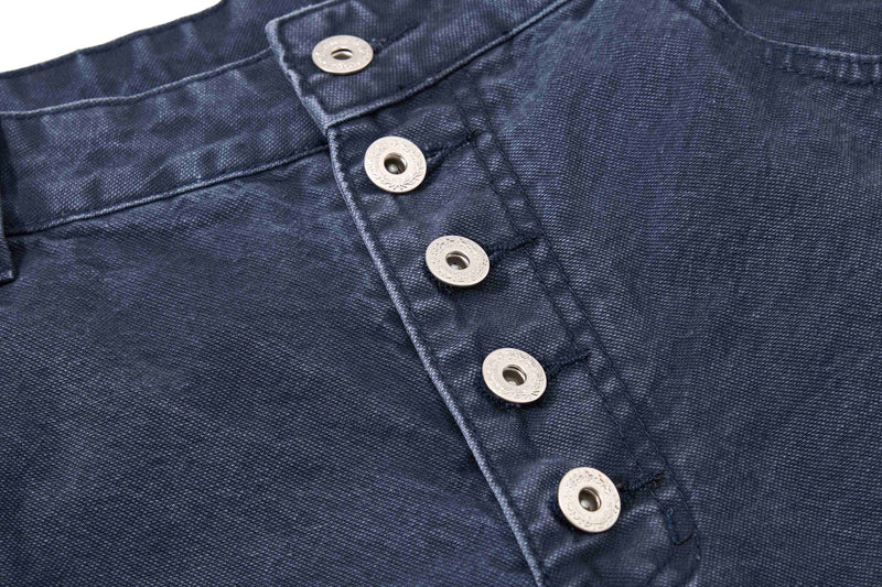 Close-up of dark wash denim shorts button fly and front waistband