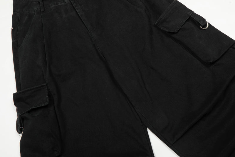 Black cargo pants leg with flap pocket and metal ring detail on the side